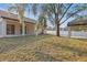 Expansive backyard featuring a carport, complemented by new white fencing, and lush landscaping, creating a serene outdoor space at 355 Anderson Dr, Groveland, FL 34736