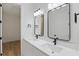 Bright bathroom featuring double sinks, matte black fixtures, and hardwood style flooring at 355 Anderson Dr, Groveland, FL 34736