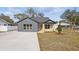 Single-story home boasting contemporary design with new driveway, lawn, and tidy landscaping at 355 Anderson Dr, Groveland, FL 34736