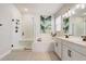 Bright bathroom featuring double vanity, soaking tub, and glass enclosed shower, perfect for relaxation at 362 Sofia Ln, Lake Alfred, FL 33850