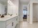 Bathroom featuring tile flooring, a double vanity with elegant fixtures, and a view into the adjacent bedroom at 362 Sofia Ln, Lake Alfred, FL 33850