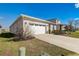 Showing the home's ample driveway and a manicured lawn, under a bright blue sky at 362 Sofia Ln, Lake Alfred, FL 33850