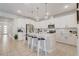 Bright kitchen features white cabinets, stainless steel appliances, an island with seating, and modern pendant lighting at 362 Sofia Ln, Lake Alfred, FL 33850