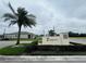 Eastgrove community entrance sign with manicured landscaping and a mature palm tree under a cloudy sky at 3762 Sungrove Cir, Sanford, FL 32771