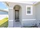 Arched entryway with a gray front door and a window to the right at 3762 Sungrove Cir, Sanford, FL 32771