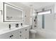 Bathroom featuring a dual sink vanity, modern lighting, and a shower-tub combo with blue tile accent at 4087 Clock Tower Dr, Port Orange, FL 32129