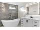 Bright bathroom featuring a soaking tub, vanity with drawers, and a stone accent wall at 4087 Clock Tower Dr, Port Orange, FL 32129