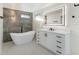 Modern bathroom with a soaking tub, vanity with drawers, and stone accent wall at 4087 Clock Tower Dr, Port Orange, FL 32129