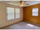 Bedroom with an orange accent wall, carpet, two windows and ceiling fan at 435 Pleasant St, Lake Helen, FL 32744