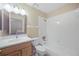 Bathroom with oak vanity, white sink, a tub-shower with white tile surround at 483 Green Spring Cir, Winter Springs, FL 32708