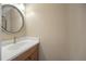 This bathroom features a wood vanity, white countertop, faucet, and round framed mirror at 483 Green Spring Cir, Winter Springs, FL 32708