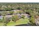 An aerial view showcases a waterfront property with a screened-in pool, complemented by lush landscaping and mature trees at 490 Wekiva Preserve Dr, Apopka, FL 32712