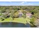 An aerial view captures a property with a screened-in pool overlooking a scenic lake, surrounded by verdant trees at 490 Wekiva Preserve Dr, Apopka, FL 32712