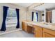 Bathroom featuring double sinks, wood cabinets, large mirror, and natural light from the window at 490 Wekiva Preserve Dr, Apopka, FL 32712