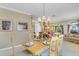 Elegant dining area with a chandelier, wooden table, and a glimpse into a cozy living space at 490 Wekiva Preserve Dr, Apopka, FL 32712