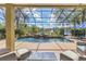 A screened-in pool with waterfall feature surrounded by lush landscaping and lake view at 490 Wekiva Preserve Dr, Apopka, FL 32712