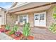 Inviting front porch with seating area, landscaped flower beds, and double door entry at 5108 Avignon Ct, Orlando, FL 32839