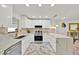 Modern kitchen with stainless steel appliances, white cabinetry and luxurious marble countertops and floors at 5108 Avignon Ct, Orlando, FL 32839