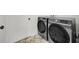 Laundry room featuring modern washer and dryer units with marble floors for a practical yet stylish space at 5108 Avignon Ct, Orlando, FL 32839