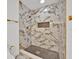 Beautiful walk-in shower featuring white marble-patterned tiling and gold fixtures at 5108 Avignon Ct, Orlando, FL 32839