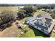 Aerial shot of the property featuring a screened pool, outdoor seating, and spacious lawn surrounded by trees at 5150 Banana Point Dr, Okahumpka, FL 34762