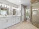 Bathroom featuring double sinks, a window, and a walk-in shower with glass door at 5150 Banana Point Dr, Okahumpka, FL 34762