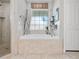 Bathroom showcasing a soaking tub with tile surround, frosted window, and a separate shower stall at 5150 Banana Point Dr, Okahumpka, FL 34762