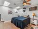 Cozy bedroom featuring a ceiling fan, skylight, and unique cowhide wall decor at 5150 Banana Point Dr, Okahumpka, FL 34762