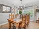 Spacious dining room featuring a wooden table, chairs, chandelier, and natural light at 5150 Banana Point Dr, Okahumpka, FL 34762