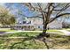 Charming home boasts a large front porch, mature trees, and a well-manicured lawn, offering curb appeal at 5150 Banana Point Dr, Okahumpka, FL 34762