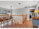 Upstairs hallway with hardwood floors and wood banister that overlooks the entryway, leading into the bedrooms at 5150 Banana Point Dr, Okahumpka, FL 34762