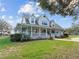 Charming two-story home featuring a welcoming front porch, manicured lawn, and picturesque landscaping at 5150 Banana Point Dr, Okahumpka, FL 34762