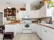 A charming kitchen featuring white cabinets, wood countertops, white appliances, and a tile floor at 5150 Banana Point Dr, Okahumpka, FL 34762
