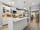 The bright kitchen features white cabinets, stainless appliances, and a spacious island, perfect for cooking at 5150 Banana Point Dr, Okahumpka, FL 34762