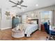 This bedroom has a soft blue motif, a ceiling fan, and bright natural light at 5150 Banana Point Dr, Okahumpka, FL 34762