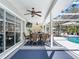 Covered outdoor dining area featuring elegant table set, ceiling fans, and views of the screened pool at 5150 Banana Point Dr, Okahumpka, FL 34762