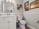 Cozy powder room featuring a modern vanity, toilet, and decorative wall art at 5150 Banana Point Dr, Okahumpka, FL 34762