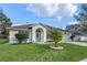 Charming single-story home featuring a two-car garage, arched entryway, and well-manicured front yard at 5173 Clarion Oaks Dr, Orlando, FL 32808