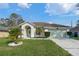 Charming single-story home featuring a two-car garage, arched entryway, and well-manicured front yard at 5173 Clarion Oaks Dr, Orlando, FL 32808