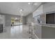 Open-concept living space with tile flooring, granite countertops, modern lighting, and sliding door to the pool at 5173 Clarion Oaks Dr, Orlando, FL 32808