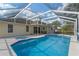 Outdoor pool area featuring a hot tub, screened in enclosure, and tan-colored home exterior at 5173 Clarion Oaks Dr, Orlando, FL 32808