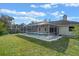 Backyard view showcasing the screened-in pool and well-maintained lawn at 5173 Clarion Oaks Dr, Orlando, FL 32808