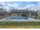 Backyard view showcasing the screened-in pool area and its surrounding landscape at 5173 Clarion Oaks Dr, Orlando, FL 32808