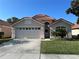 Charming single-Gathering home boasts a tile roof, well-manicured lawn, and a two-car garage at 5337 Watervista Dr, Orlando, FL 32821