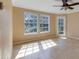 Sun-filled living room featuring neutral walls, tile floors, two large windows, and a ceiling fan at 6142 Westgate Dr # 102, Orlando, FL 32835