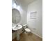 A simple bathroom with a pedestal sink, toilet, and a neutral-colored tile floor at 6292 Twain Street # 108, Orlando, FL 32835