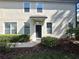 Front entrance to the townhome with a black door, decorative windows and a tidy lawn at 6292 Twain Street # 108, Orlando, FL 32835