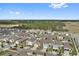 Drone shot of a suburban neighborhood showcasing uniform homes and orderly street, near lush green forests at 6745 Huntleigh Hammock Rd, Harmony, FL 34773