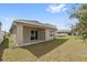 Exterior view of the home's backyard and covered patio on a sunny day at 6745 Huntleigh Hammock Rd, Harmony, FL 34773