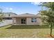 Back of the house with covered patio, sliding glass doors, and a view of the well-maintained lawn and backyard at 6745 Huntleigh Hammock Rd, Harmony, FL 34773